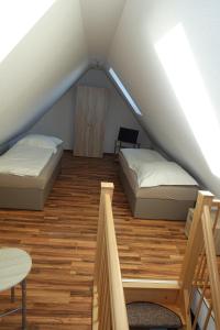 um quarto no sótão com 2 camas e uma mesa em Gästewohnung 16 em Oschersleben