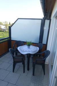 een tafel met stoelen en een plant op een balkon bij Gästewohnung 16 in Oschersleben