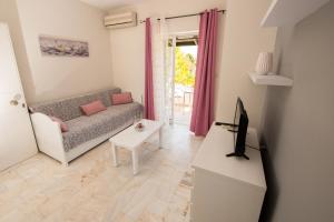 a living room with a couch and a table at Ifigenia's Apartments in Stoupa