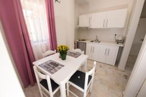 a small kitchen with a white table and chairs at Ifigenia's Apartments in Stoupa