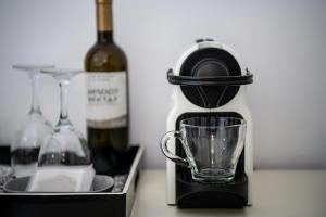 a bottle of wine and a blender and a glass at Shalom Luxury Rooms Daliani in Chania Town