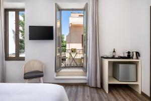 a bedroom with a bed and a view of a balcony at Shalom Luxury Rooms Daliani in Chania Town
