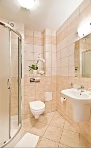 W łazience znajduje się toaleta, umywalka i prysznic. w obiekcie Villa Arstone w Świnoujściu