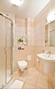 a bathroom with a toilet and a sink and a shower at Villa Arstone in Świnoujście