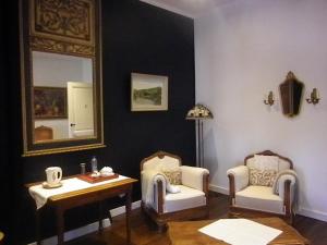 a room with two chairs and a table and a mirror at Château de Bonne Espérance in Huy