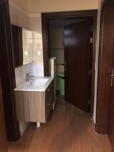 baño con lavabo y espejo grande en Bait Alsadaqa Aparthotel, en Abha