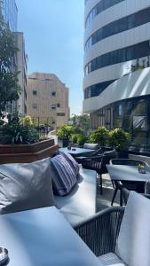 einen Balkon mit Tischen und Kissen auf einem Gebäude in der Unterkunft Pupin Palata business apartman B5 in Novi Sad