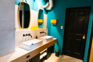 a bathroom with two sinks and two mirrors at illi Nakano in Tokyo