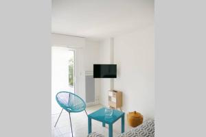 un salon avec une table bleue et une télévision dans l'établissement Studio situé dans le centre de Saint Philibert, à Saint-Philibert