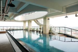 a large swimming pool in a building with water at Best Location 1BR Apartment at Atlanta Residences By Travelio in Kukusan