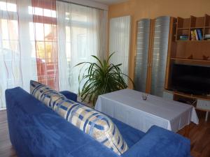 ein Wohnzimmer mit einem blauen Sofa und einem Tisch in der Unterkunft Ferienwohnung Am Deich in Bleckede