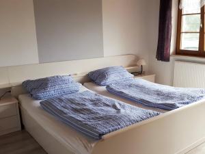 WeilheimにあるFerienwohnung Eckertのベッドルームに枕付きのベッド2台が備わります。