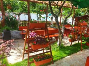 a garden with a table and benches with flowers at Комплекс Кремен in Blagoevgrad