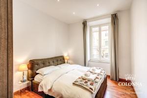 Un dormitorio con una cama grande y una ventana en Colonna Suite - Rome San Giovanni, en Roma