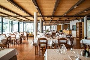 a restaurant with tables and chairs with white tablecloths at Agritur Acetaia Gourmet&Relax in Tenno