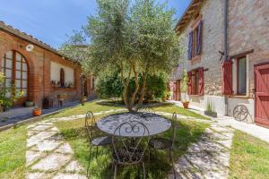 a table and chairs in a yard with a tree at B&B du Couvent, vue château in Giroussens