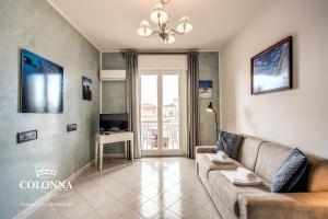 a living room with a couch and a television at Colonna Suite - Rome San Giovanni in Rome