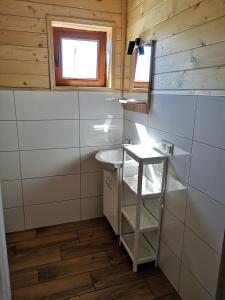 a small bathroom with a sink and a window at LAZUROWY ZAKĄTEK in Niechorze