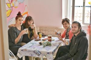 un grupo de personas sentadas alrededor de una mesa bebiendo café en Old Town Hostel Split, en Split