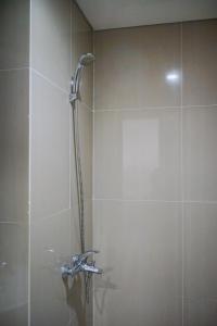 a shower with a shower head in a bathroom at Cozy and Sweet Studio at Paramount Skyline Apartment By Travelio in Tangerang