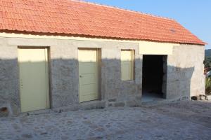 ein Gebäude mit zwei Türen und einem roten Dach in der Unterkunft A casa do meu Avô in Viana do Castelo