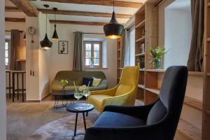 un soggiorno con sedie e tavolo di Natura Boutique Chalet Wellness SPA a Dobbiaco