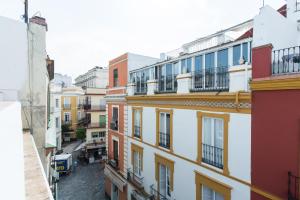 an apartment building with balconies on a city street at DreamsApt Plaza Nueva in Seville