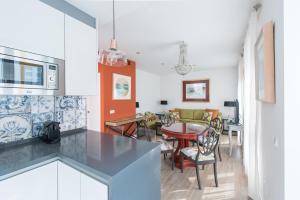 a kitchen and living room with a table and chairs at DreamsApt Plaza Nueva in Seville