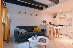 コルマールにあるAppartement La Terrasse sur courのソファとテーブルのあるリビングルーム