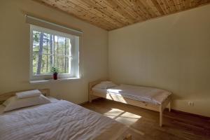 1 dormitorio con 2 camas y ventana en Roostasalu Holiday home en Noarootsi