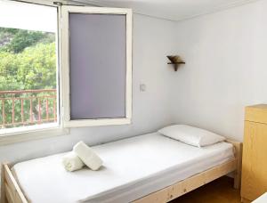 1 dormitorio con 2 camas y ventana en Villa Astraea Kyra Panagia, en Kyra Panagia