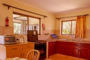 uma cozinha com um lavatório e um fogão forno superior em Ol-Kine Cottage at The Great Rift Valley Lodge & Golf Resort Naivasha em Naivasha