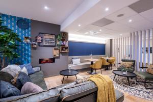 ein Wohnzimmer mit Couch und Tischen in der Unterkunft Mercure Oostende in Ostende
