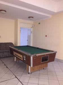 a living room with a pool table in a room at Hotel Familia in Zamárdi