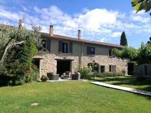 una gran casa de piedra con un patio de césped en Mas de la Gramillère, en Barbentane