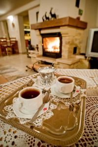 a tray with two cups of coffee on a table with a fireplace at Willa Bachledówka in Zakopane