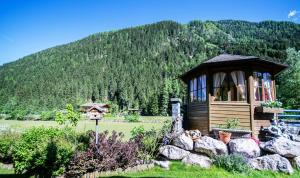 eine kleine Hütte auf einem Feld mit einem Berg in der Unterkunft Haus Wulfenia in Neustift im Stubaital