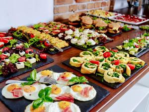 a table with many different types of food on plates at Hotel Mużakowski in Łęknica