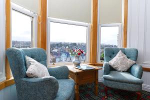 Duas cadeiras e uma mesa num quarto com janelas em Castle Walk Bed & Breakfast em Stirling