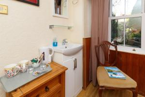 a bathroom with a sink and a counter with a chair at Castle Walk Bed & Breakfast in Stirling