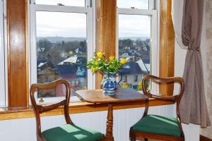uma mesa com duas cadeiras e um vaso de flores numa janela em Castle Walk Bed & Breakfast em Stirling