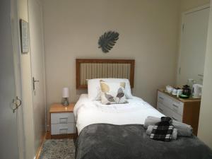 um quarto com uma cama com lençóis brancos e almofadas em Otters Green em Botley