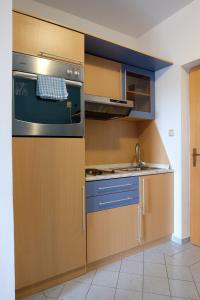 a kitchen with a stove and a sink at Apartman Rab Blue in Rab