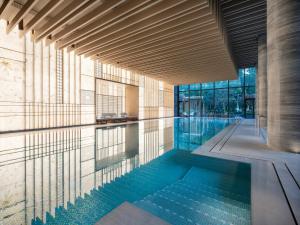 uma piscina com água azul num edifício em Park Hyatt Suzhou em Suzhou
