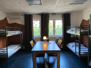 Cette chambre comprend une table et des lits superposés. dans l'établissement PREMIUM Hostel, à Berlin