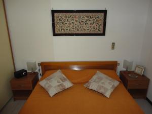 una camera da letto con un letto con due comodini e una foto sul muro di Fede & Francy a Quartu SantʼElena
