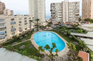 uma vista panorâmica de uma grande piscina numa cidade em Apartamento a un minuto de la playa de Levante em Benidorm