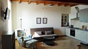 a living room with a couch and a table in a kitchen at Agriturismo Corte Speranza in Guidizzolo