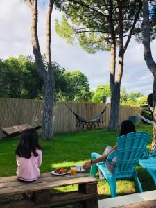 two girls sitting on chairs on a picnic table in a backyard at HALT HOTEL - Choisissez l'Hôtellerie Indépendante in Lattes +71 photos