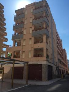 ein hohes Gebäude mit einer Parkgarage davor in der Unterkunft Edificio Mirasierra in Oropesa del Mar